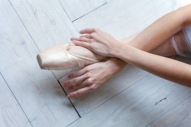 Balerin eller dans dersi bacağından pointe ayakkabı koyar