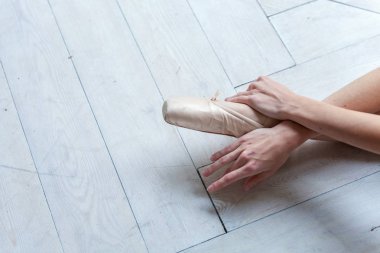 Balerin eller dans dersi bacağından pointe ayakkabı koyar