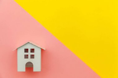 Sarı ve pembe renkli trendy modern pastel arka planda izole minyatür beyaz oyuncak ev ile sadece minimal tasarım