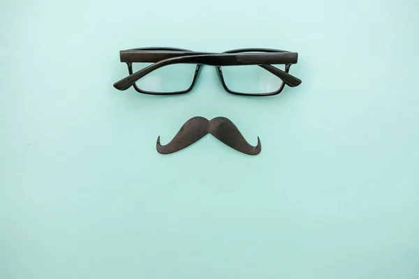Le concept de la fête des pères heureux. Signe de moustache avec des lunettes isolées sur fond bleu pastel. Symbole silhouette homme — Photo
