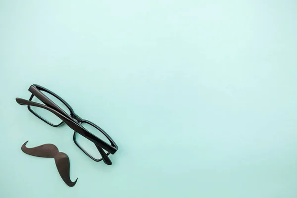 Happy Vaderdag concept. Teken van snor met een bril geïsoleerd op pastel blauwe achtergrond. Man silhouet symbool — Stockfoto