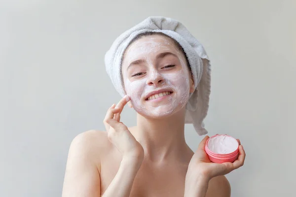 Retrato de belleza de mujer en toalla en la cabeza con máscara blanca nutritiva o crema en la cara, fondo blanco aislado —  Fotos de Stock