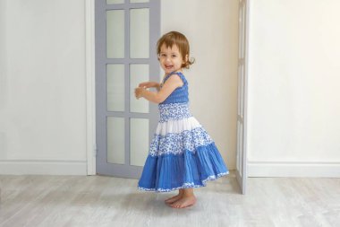 Evde parlak ışık oturma odasında dans ve gülen küçük kız