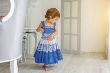 Evde parlak ışık oturma odasında dans ve gülen küçük kız