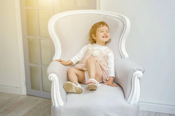 Little girl sitting on modern chair