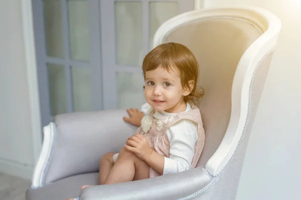 Klein meisje zittend op moderne stoel — Stockfoto