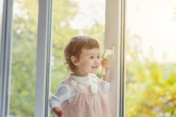 Petite fille debout sur le rebord de la fenêtre — Photo