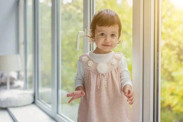 Petite fille debout sur le rebord de la fenêtre — Photo