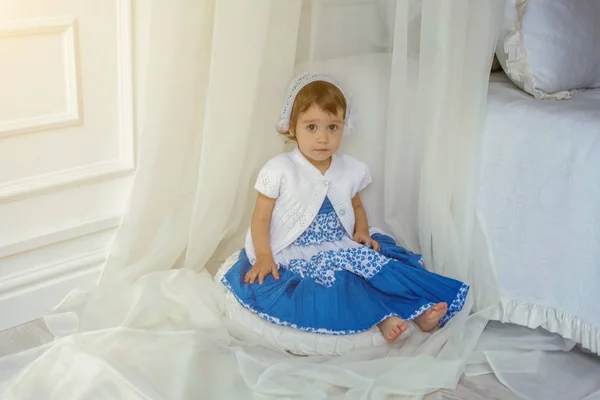 Schattig klein meisje spelen in lichte witte slaapkamer — Stockfoto
