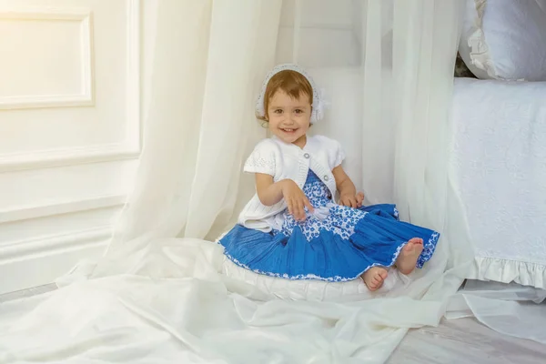 Schattig klein meisje spelen in lichte witte slaapkamer — Stockfoto