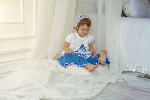 Schattig klein meisje spelen in lichte witte slaapkamer — Stockfoto