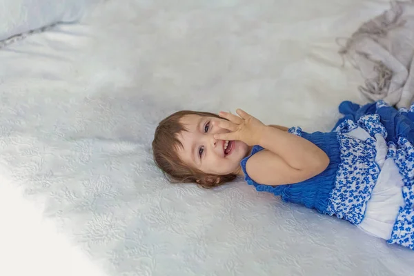 Carino bambina che salta sul letto bianco — Foto Stock