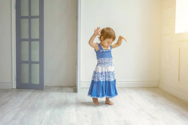 Petite fille dansant dans la lumière vive salon à la maison et riant — Photo