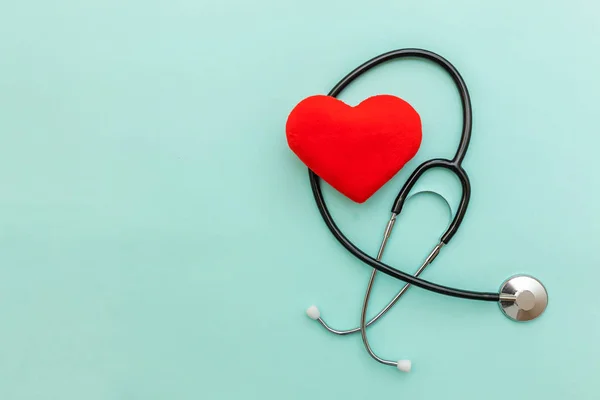 Medicine equipment stethoscope or phonendoscope and red heart isolated on trendy pastel blue background. Instrument device for doctor. Health care life insurance concept — Stock Photo, Image