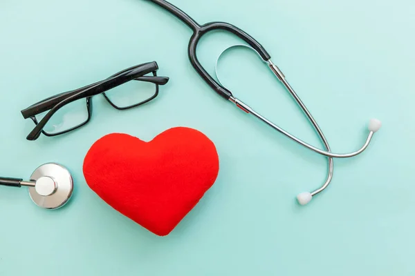 Medicine equipment stethoscope or phonendoscope glasses and red heart isolated on trendy pastel blue background. Instrument device for doctor. Health care life insurance concept — Stock Photo, Image