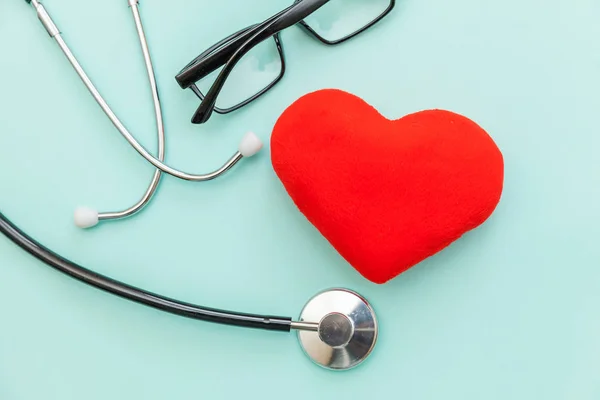 Medicine equipment stethoscope or phonendoscope glasses and red heart isolated on trendy pastel blue background. Instrument device for doctor. Health care life insurance concept — Stock Photo, Image