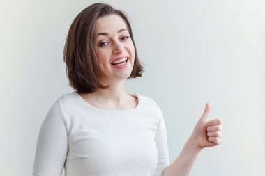Güzellik portre genç mutlu pozitif esmer kadın beyaz arka plan izole üzerinde el başparmak gösteren