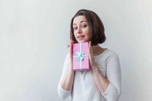 Jeune femme positive tenant petite boîte cadeau rose isolé sur fond blanc. Préparation pour les vacances. Fille regardant heureux et excité — Photo