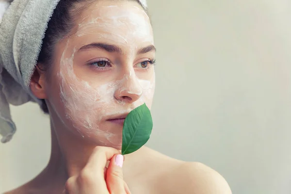 Cara de mulher com folha verde e creme ou máscara nutritiva — Fotografia de Stock