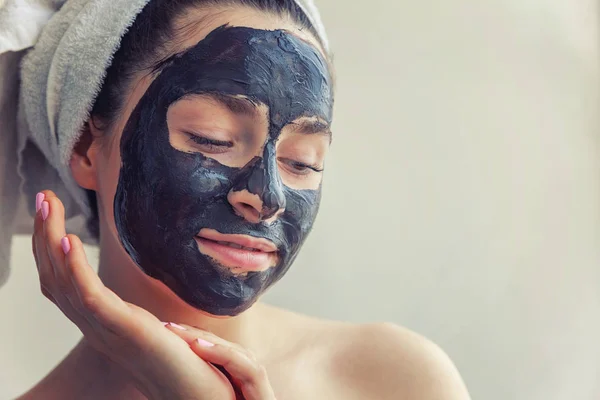 Kadının yüzündeki siyah besleyici maske uygulamak — Stok fotoğraf