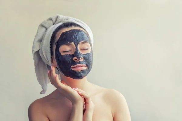 Γυναίκα εφαρμόζοντας μαύρο θρεπτική μάσκα στο πρόσωπό — Φωτογραφία Αρχείου
