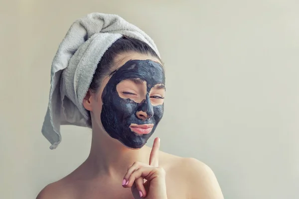 Mujer aplicando máscara negra nutritiva en la cara — Foto de Stock