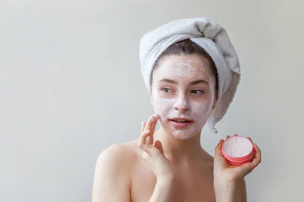 Schoonheid portret van de vrouw in handdoek op hoofd met witte voedende masker of crème op gezicht, witte achtergrond geïsoleerd — Stockfoto