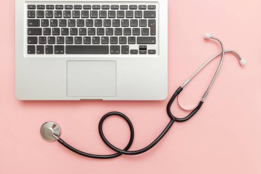 Pembe arka plan üzerinde izole Stetoskop klavye dizüstü bilgisayar. Modern tıbbi Bilgi teknolojisi ve sofware gelişmeler kavramı. Bilgisayar ve gadget tanılama ve onarım