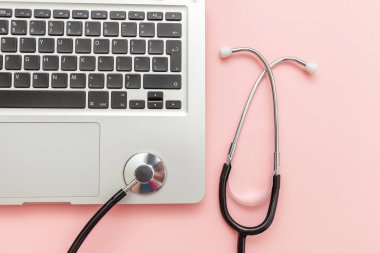 Pembe arka plan üzerinde izole Stetoskop klavye dizüstü bilgisayar. Modern tıbbi Bilgi teknolojisi ve sofware gelişmeler kavramı. Bilgisayar ve gadget tanılama ve onarım
