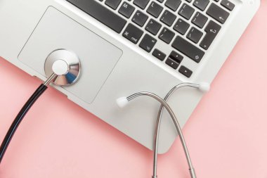Pembe arka plan üzerinde izole Stetoskop klavye dizüstü bilgisayar. Modern tıbbi Bilgi teknolojisi ve sofware gelişmeler kavramı. Bilgisayar ve gadget tanılama ve onarım