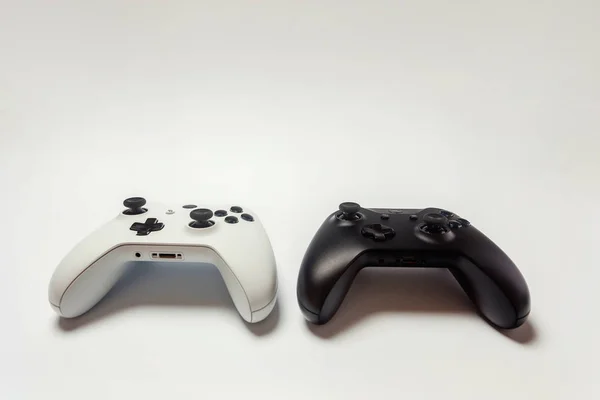 Blanco y negro dos joystick sobre fondo blanco. Juegos de ordenador tecnología jugar competencia videojuego control confrontación concepto —  Fotos de Stock