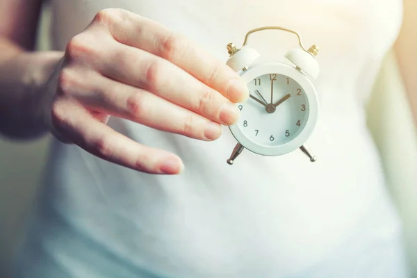 Female woman hands holding ringing twin bell vintage classic alarm clock