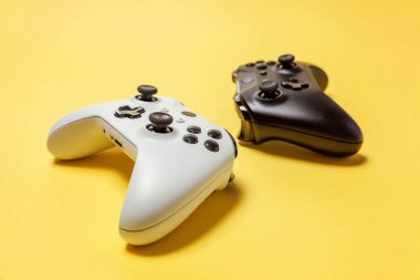 Sarı arka planda beyaz ve siyah iki joystick. Bilgisayar oyun Yarışması videogame kontrol çatışma kavramı