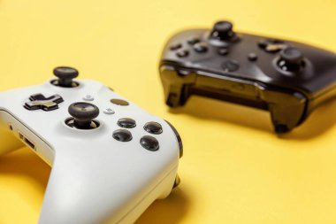 Sarı arka planda beyaz ve siyah iki joystick. Bilgisayar oyun Yarışması videogame kontrol çatışma kavramı