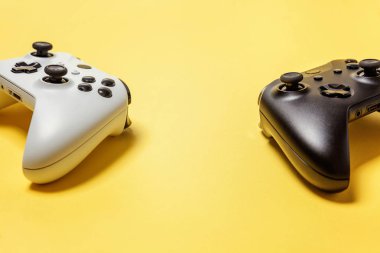 Sarı arka planda beyaz ve siyah iki joystick. Bilgisayar oyun Yarışması videogame kontrol çatışma kavramı