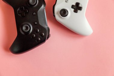 Pembe arka planda beyaz ve siyah iki joystick. Bilgisayar oyunu yarışması video oyunu kontrol yüzleşme kavramı