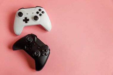Pembe arka planda beyaz ve siyah iki joystick. Bilgisayar oyunu yarışması video oyunu kontrol yüzleşme kavramı