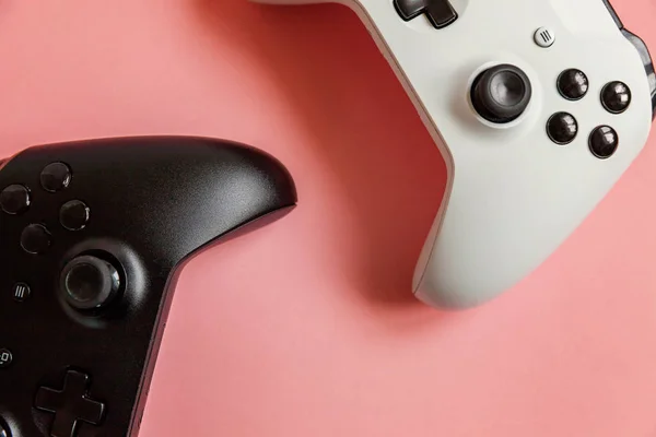 Blanc et noir deux joystick sur fond rose. Concurrence de jeux vidéo concept de confrontation de contrôle de jeu vidéo — Photo