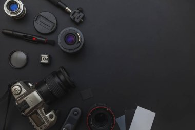 DSLR kamera sistemi, kamera Temizleme Kiti, koyu siyah masa arka planda objektif ve kamera aksesuarı ile fotoğrafçı çalışma alanı