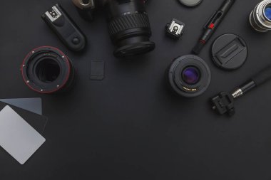 DSLR kamera sistemi, kamera Temizleme Kiti, koyu siyah masa arka planda objektif ve kamera aksesuarı ile fotoğrafçı çalışma alanı