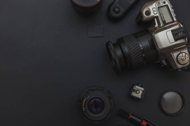 DSLR kamera sistemi, kamera Temizleme Kiti, koyu siyah masa arka planda objektif ve kamera aksesuarı ile fotoğrafçı çalışma alanı