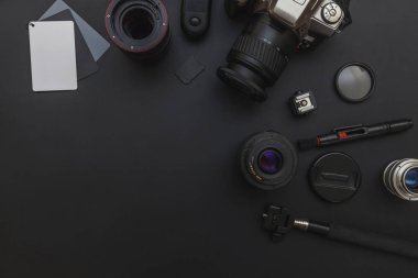 DSLR kamera sistemi, kamera Temizleme Kiti, koyu siyah masa arka planda objektif ve kamera aksesuarı ile fotoğrafçı çalışma alanı
