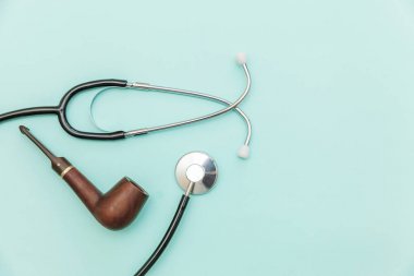 Erkek sağlık konsepti. Tıp ekipmanları stetoskop veya fonndoskop sigara boru trendy pastel mavi arka plan izole