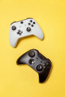Sarı arka planda beyaz ve siyah iki joystick. Bilgisayar oyun Yarışması videogame kontrol çatışma kavramı
