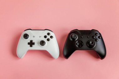 Pembe arka planda beyaz ve siyah iki joystick. Bilgisayar oyunu yarışması video oyunu kontrol yüzleşme kavramı