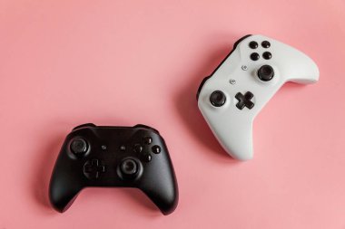Pembe arka planda beyaz ve siyah iki joystick. Bilgisayar oyunu yarışması video oyunu kontrol yüzleşme kavramı