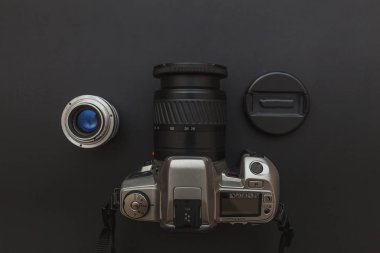 Koyu siyah masa arka planı üzerinde dslr kamera sistemi ve lens ile Fotoğrafçı işyeri. Hobi seyahat fotoğrafçılığı konsepti