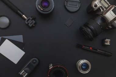 DSLR kamera sistemi, kamera Temizleme Kiti, koyu siyah masa arka planda objektif ve kamera aksesuarı ile fotoğrafçı çalışma alanı