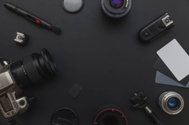 DSLR kamera sistemi, kamera Temizleme Kiti, koyu siyah masa arka planda objektif ve kamera aksesuarı ile fotoğrafçı çalışma alanı