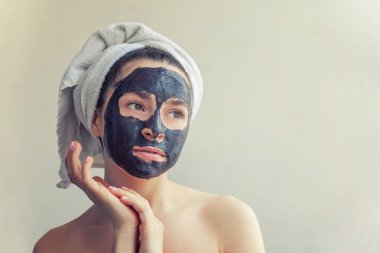 Kadının yüzündeki siyah besleyici maske uygulamak